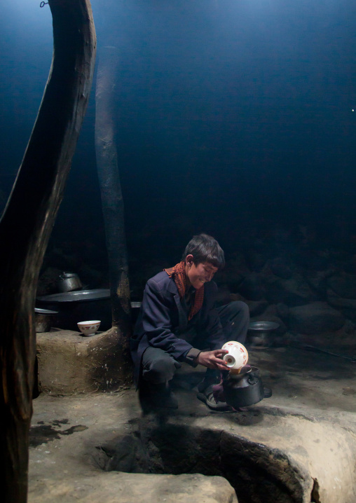 Wakhi teenage boy preparing salty milk tea inside his house, Big pamir, Wakhan, Afghanistan