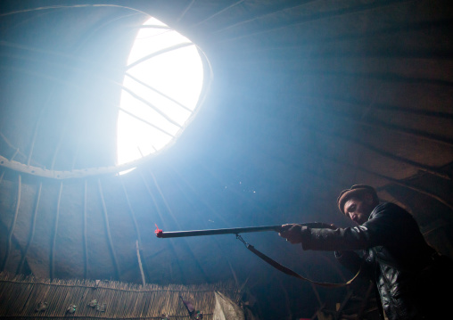 Wakhi nomad man with his gun inside his yurt, Big pamir, Wakhan, Afghanistan