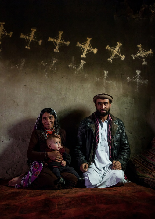 Afghan family inside their traditional pamiri house with the walls decorated for nowruz, Badakhshan province, Zebak, Afghanistan