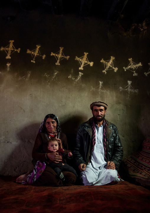 Afghan family inside their traditional pamiri house with the walls decorated for nowruz, Badakhshan province, Zebak, Afghanistan