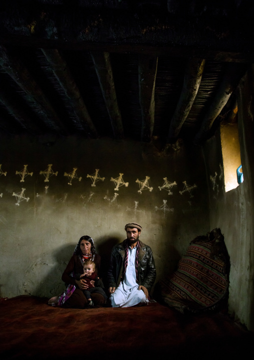 Afghan family inside their traditional pamiri house with the walls decorated for nowruz, Badakhshan province, Zebak, Afghanistan