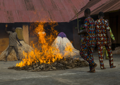 Benin, West Africa, Porto-Novo, men putting fire to a zangbeto guardian of the night in the royal palace