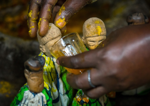 Benin, West Africa, Bopa, miss ablossi giving drink to the carved wooden figures of her five dead twins