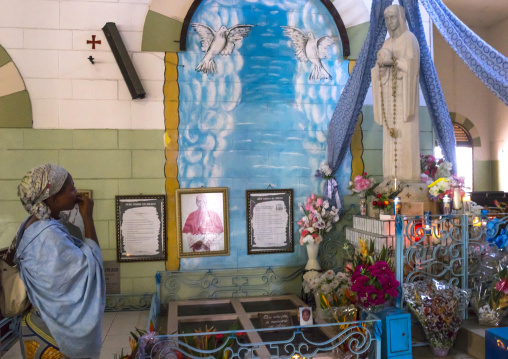 Benin, West Africa, Cotonou, woman praying inside the notre dame roman catholic cathedral