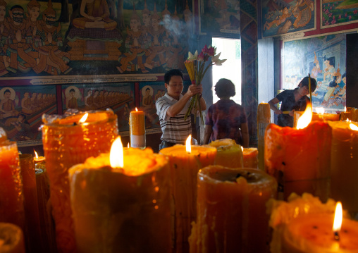 Cambodian man making offerings with lotus fowers in a temple, Phnom Penh province, Phnom Penh, Cambodia