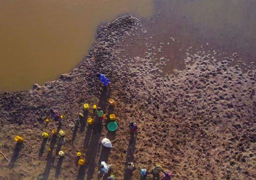 Aerial view of Borana tribe people filling jerricans in a water reservoir used for animals, Oromia, Yabelo, Ethiopia