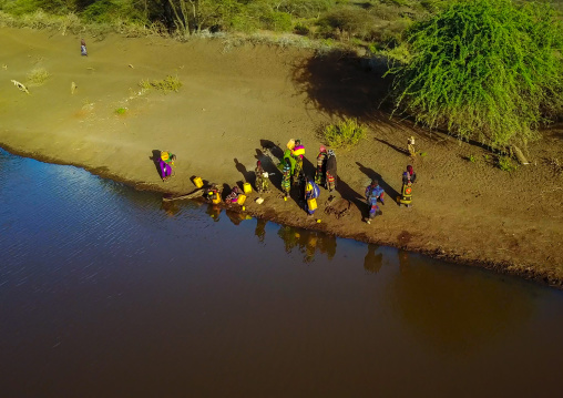 Aerial view of Borana tribe people filling jerricans in a water reservoir used for animals, Oromia, Yabelo, Ethiopia