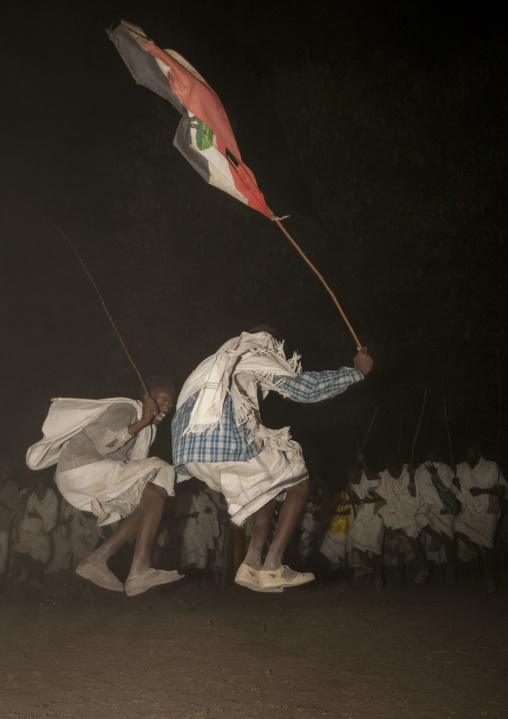 Night Shot Of Two Karrayyu Tribe Men Jumping During A Choreographed Stick Dance At Gadaaa Ceremony, Metahara, Ethiopia