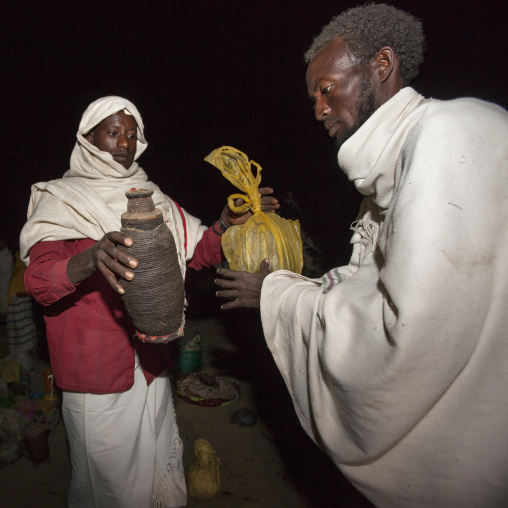 Night Shot Of A Karrayyu Tribe Man Bringing Food To Another Karrayyu Family During Gadaaa Ceremony, Metahara, Ethiopia