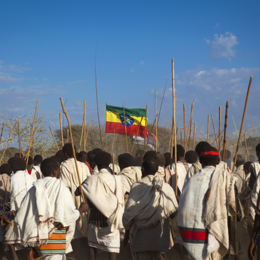 Rear View Of A Group Of Karrayyu Tribe Men Carrying The Ethiopian Flag And The Oromo Flags During Gadaaa Ceremony, Metahara, Ethiopia