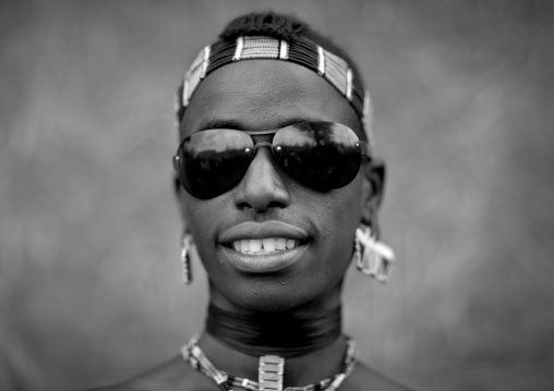 Fashionable tsemay tribe man posing with sunglasses in key afer, Omo valley, Ethiopia