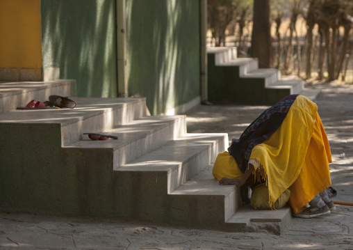 Old woman kissing the stairs of a church, Zway, Ehtiopia