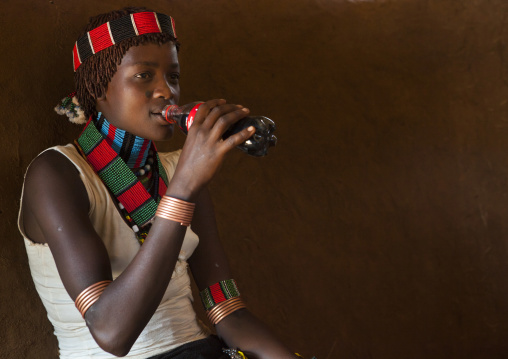 Hamer Tribe Woman In Traditional Outfit Drinking A Coca Cola, Turmi, Omo Valley, Ethiopia