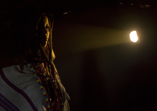 Karrayyu Tribe Woman Inside Her House Lighten By A Ray Of Light, Metahara, Ethiopia