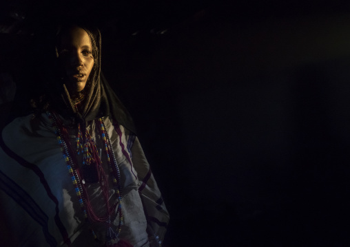 Karrayyu Tribe Woman Inside Her House Lighten By A Ray Of Light, Metahara, Ethiopia