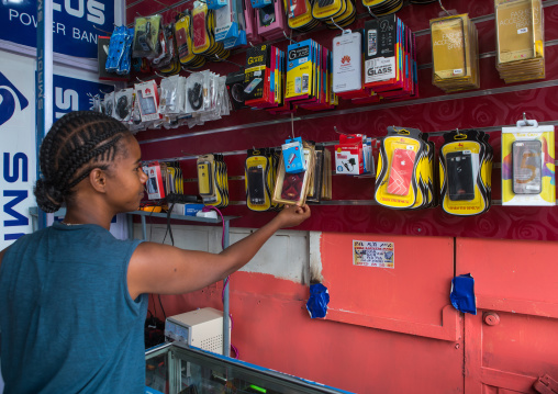 A karrayyu tribe girl called aliya who was the first girl educated in her tribe in a mobile phone shop, Addis abeba region, Addis ababa, Ethiopia