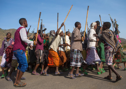 Oromo men with canes and kalashnikovs dancing during a wedding celebration, Oromo, Sambate, Ethiopia