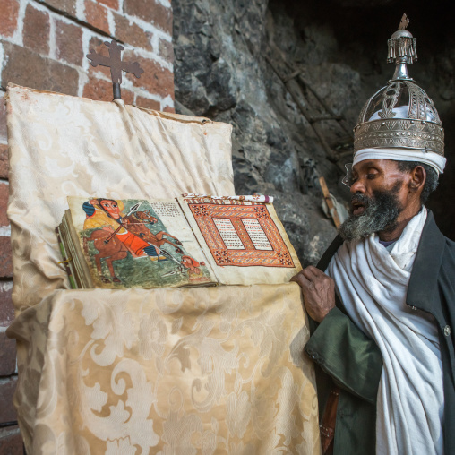 Ethiopian orthodox priest with an old bible in nakuto lab rock church, Amhara region, Lalibela, Ethiopia