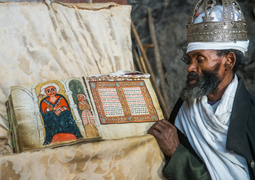 Ethiopian orthodox priest with an old bible in nakuto lab rock church, Amhara region, Lalibela, Ethiopia