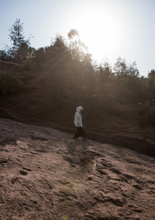 Ethiopian woman walking down a hill, Amhara region, Lalibela, Ethiopia