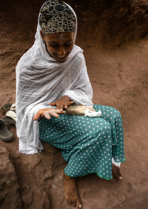 Pilgrim woman with holy soil on the hand during kidane mehret orthodox celebration, Amhara region, Lalibela, Ethiopia