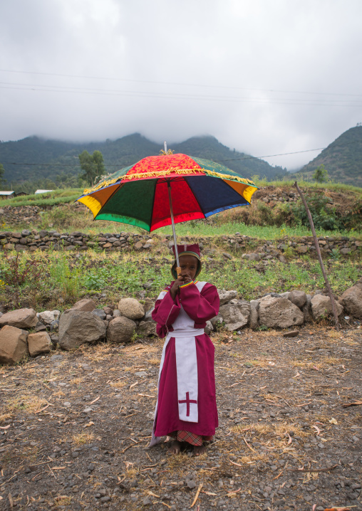 Boy collecting money in an umbrella to build a new church, Semien wollo zone, Woldia, Ethiopia