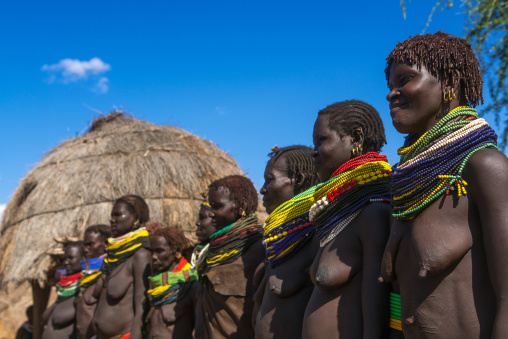 Nyangatom tribe women with huge necklaces in a line, Omo valley, Kangate, Ethiopia