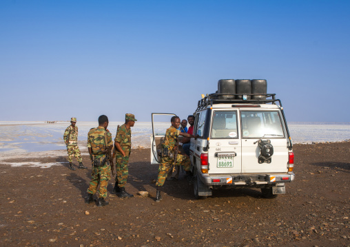 Policemen and a tourist four wheels on a salt lake, Afar region, Dallol, Ethiopia