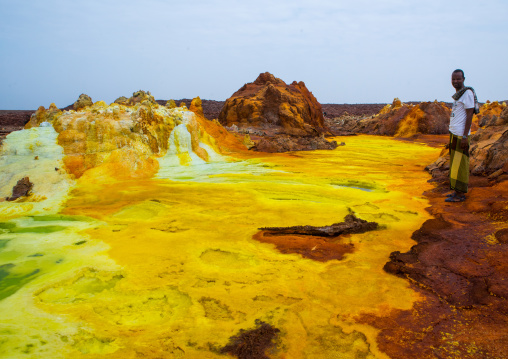 Afar man in front of colorful volcanic landscape in the danakil depression, Afar region, Dallol, Ethiopia