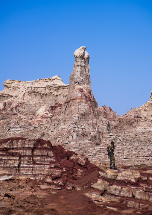 Ethiopian soldier in the salt canyons made of layers of halite and gypsum in the danakil depression, Afar region, Dallol, Ethiopia