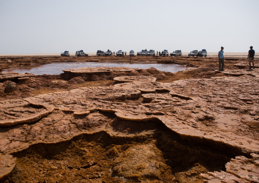 Toursist and fourt wheels in front of an acid lake in the danakil depression, Afar region, Dallol, Ethiopia