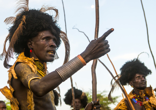 Dassanech men with leopard skins and ostrich feathers headwears during dimi ceremony to celebrate circumcision of teenagers, Omo valley, Omorate, Ethiopia