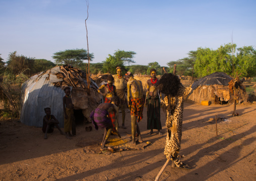 A dassanech man puts some mud on his friend body to join the dimi ceremony, Omo valley, Omorate, Ethiopia