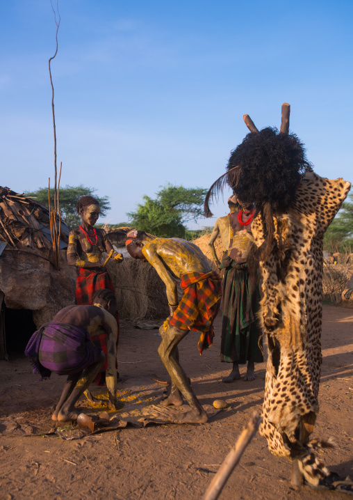 Dassanech men put mud on their bodies to join dimi ceremony to celebrate circumcision of teenagers, Omo valley, Omorate, Ethiopia