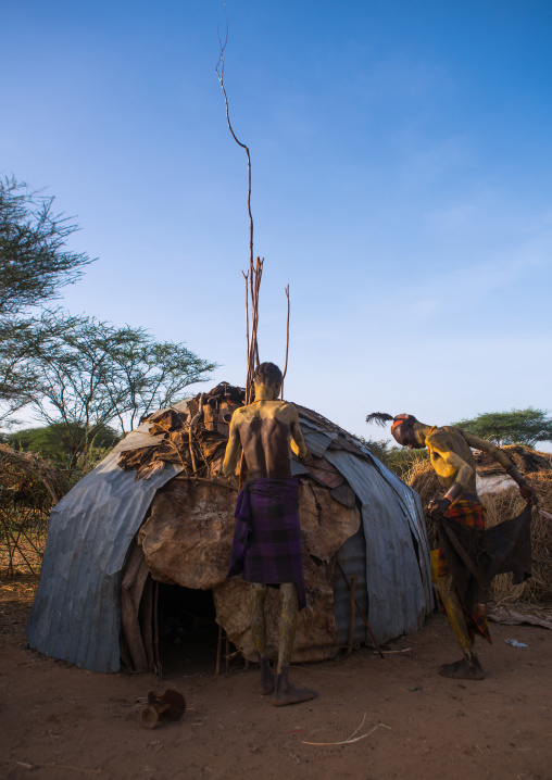 Dassanech man preparing the long sticks for dimi ceremony to celebrate circumcision of teenagers, Omo valley, Omorate, Ethiopia