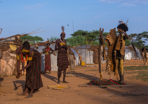 Dassanech men put on leopard skins and ostrich feathers headdresses to join dimi ceremony to celebrate circumcision of teenagers, Omo valley, Omorate, Ethiopia