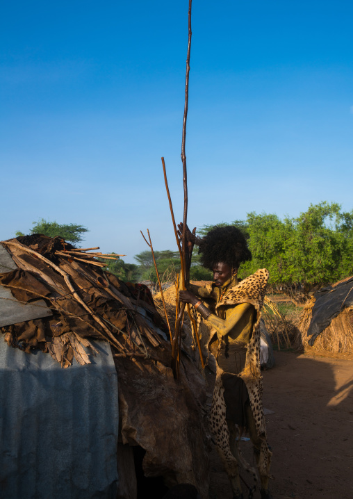 Dassanech man with leopard skin and ostrich feathers headwear during dimi ceremony to celebrate circumcision of teenagers, Omo valley, Omorate, Ethiopia