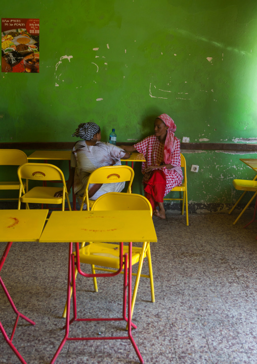 Ethiopian women sit in a multi colored restaurant, Afar region, Gewane, Ethiopia