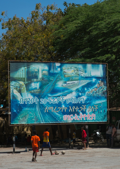 Children playing football under a propaganda billboard, Dire dawa region, Dire dawa, Ethiopia