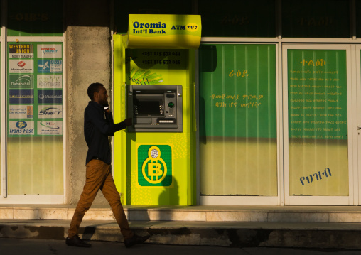 Man in front og an oromia international bank atm, Addis abeba region, Addis ababa, Ethiopia