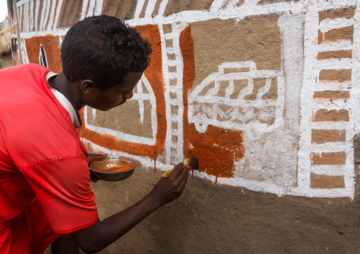 Ethiopia, Kembata, Alaba Kuito, young man painting the wall of a traditional ethiopian house