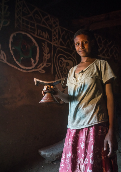 Ethiopia, Kembata, Alaba Kuito, ethiopian woman with her wooden headrest inside her decorated house