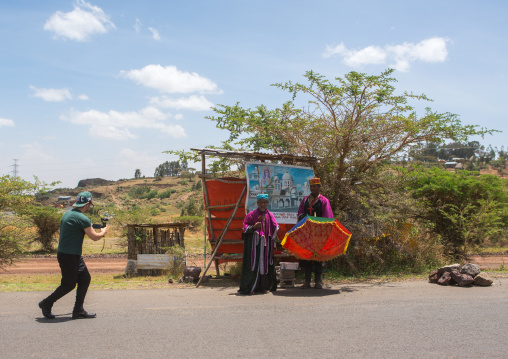 Tourist taking picture of priests collecting money a to build a new church, Addis abeba region, Addis ababa, Ethiopia