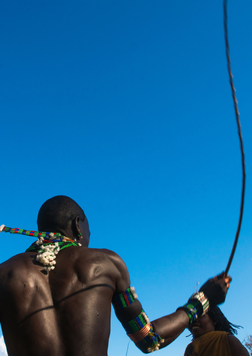 Hamer tribe maze whipping a woman during a bull jumping ceremony, Omo valley, Turmi, Ethiopia