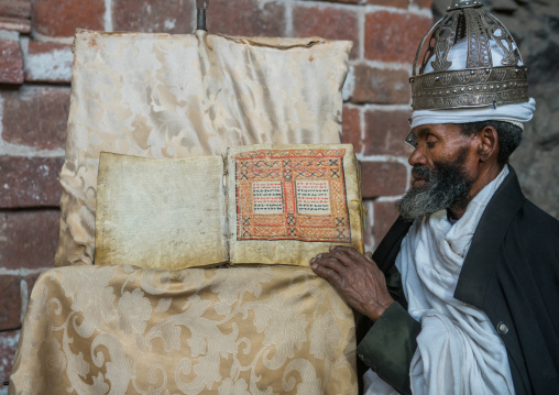 Ethiopian orthodox priest with an old bible in nakuto lab rock church, Amhara region, Lalibela, Ethiopia