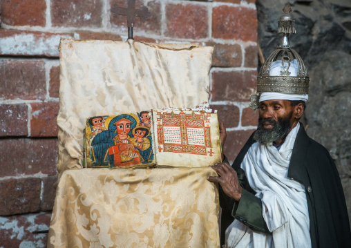 Ethiopian orthodox priest with an old bible in nakuto lab rock church, Amhara region, Lalibela, Ethiopia