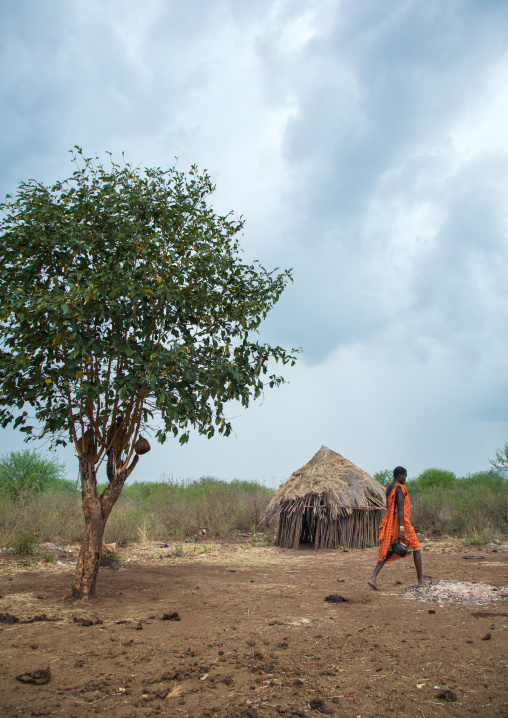 Woman passing in a bodi tribe village, Omo valley, Hana mursi, Ethiopia