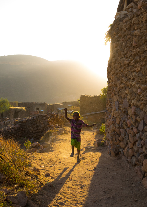 Ethiopian boy running in the streets of a traditional Argoba stone houses village near harar, Harari Region, Koremi, Ethiopia