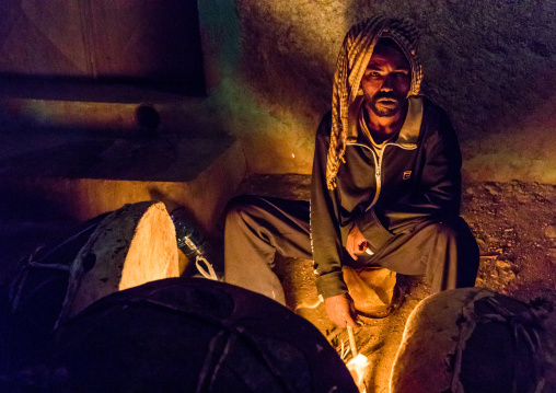 Harari man heating the drums before a ceremony in sufi community, Harari Region, Harar, Ethiopia