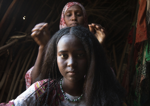 Afar woman having a traditional hairstyle inside her hut, Afar region, Afambo, Ethiopia